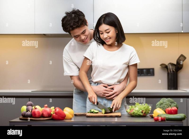 loving-asian-husband-hugging-wife-cooking-together-dinner-in-kitchen-2D12364.jpg