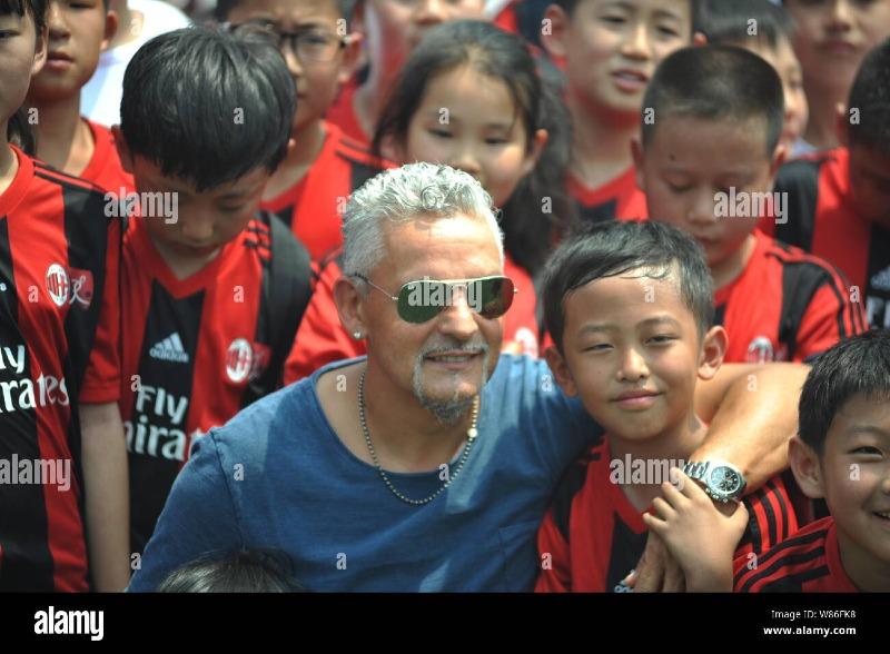 former-italian-football-superstar-roberto-baggio-left-poses-with-young-players-at-the-closing-ceremony-for-the-ac-milan-junior-camp-in-qingdao-city-W86FK8.jpg