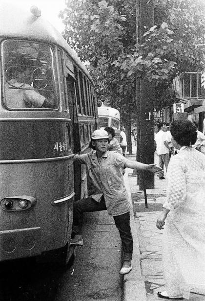 1964년_7월,_한_버스_안내_차장이_승객들의_승·하차를_돕고_있다.jpg